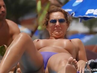 Topless milf gets some sun in the sand